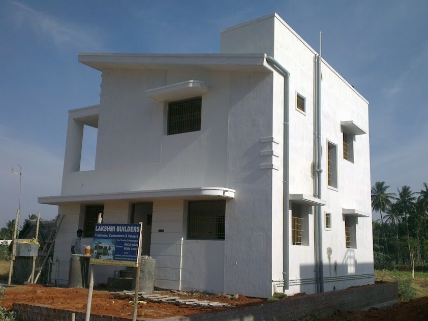 The same house painted white with the builder's board outside — in Pannimadai, Coimbatore